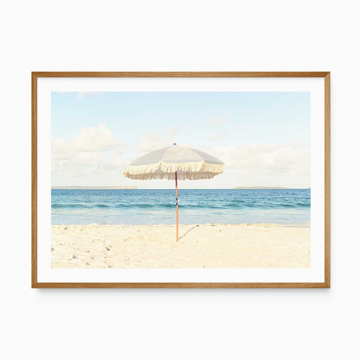 Beach umbrella wall art print featuring a neutral coastal scene with sand and ocean.