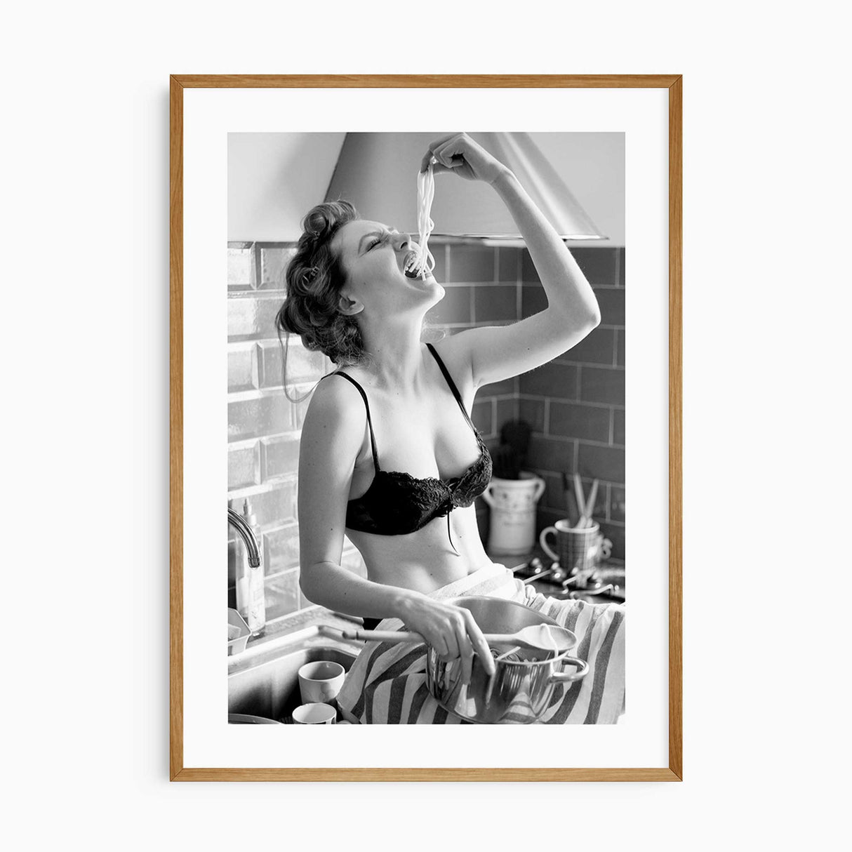 Black and white kitchen wall art featuring a glamorous woman eating spaghetti from the pot.