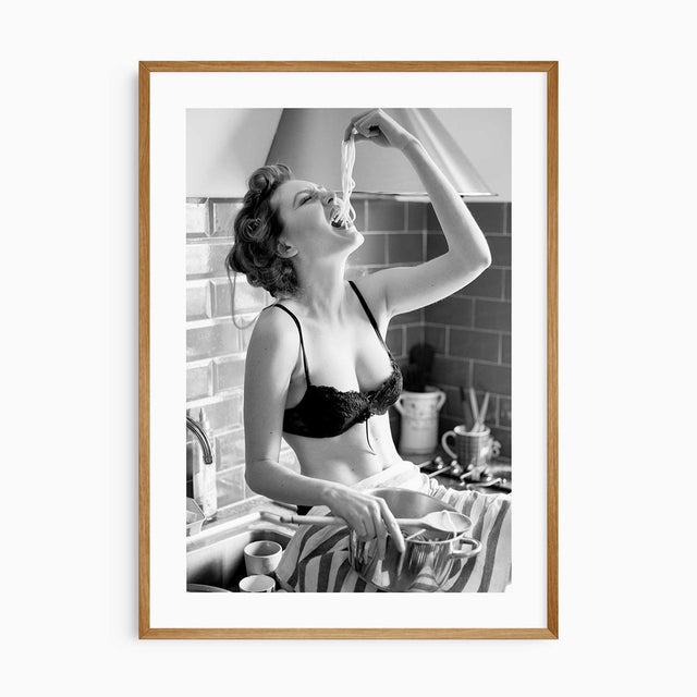 Black and white kitchen wall art featuring a glamorous woman eating spaghetti from the pot.
