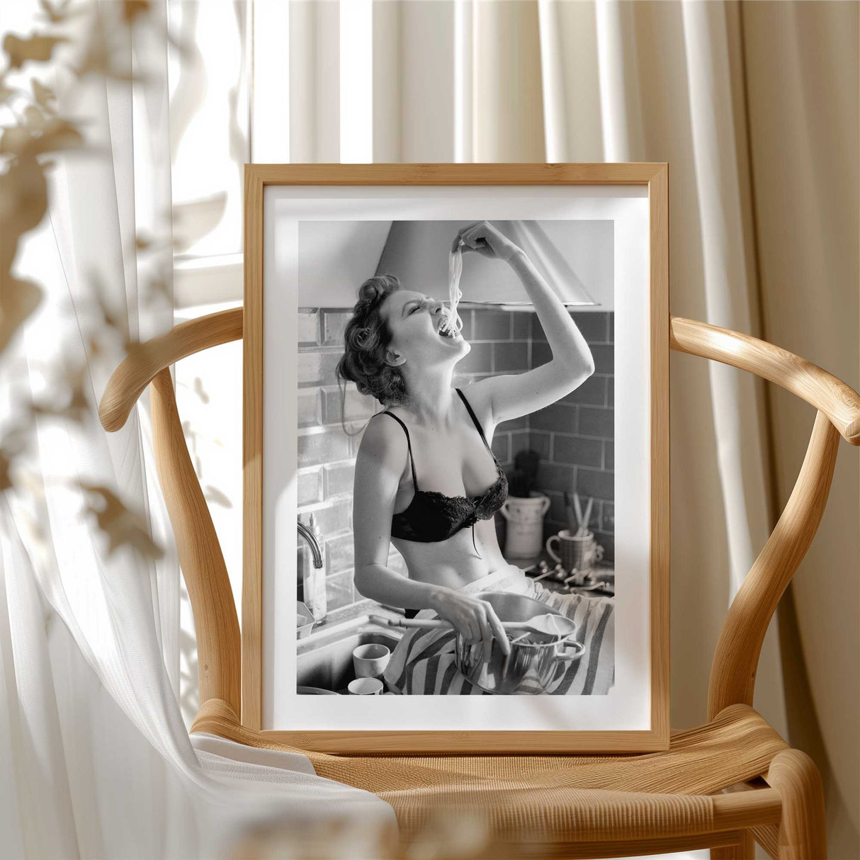 Bold black and white art print of a woman eating pasta straight from the pot – fun and feminine kitchen wall decor.