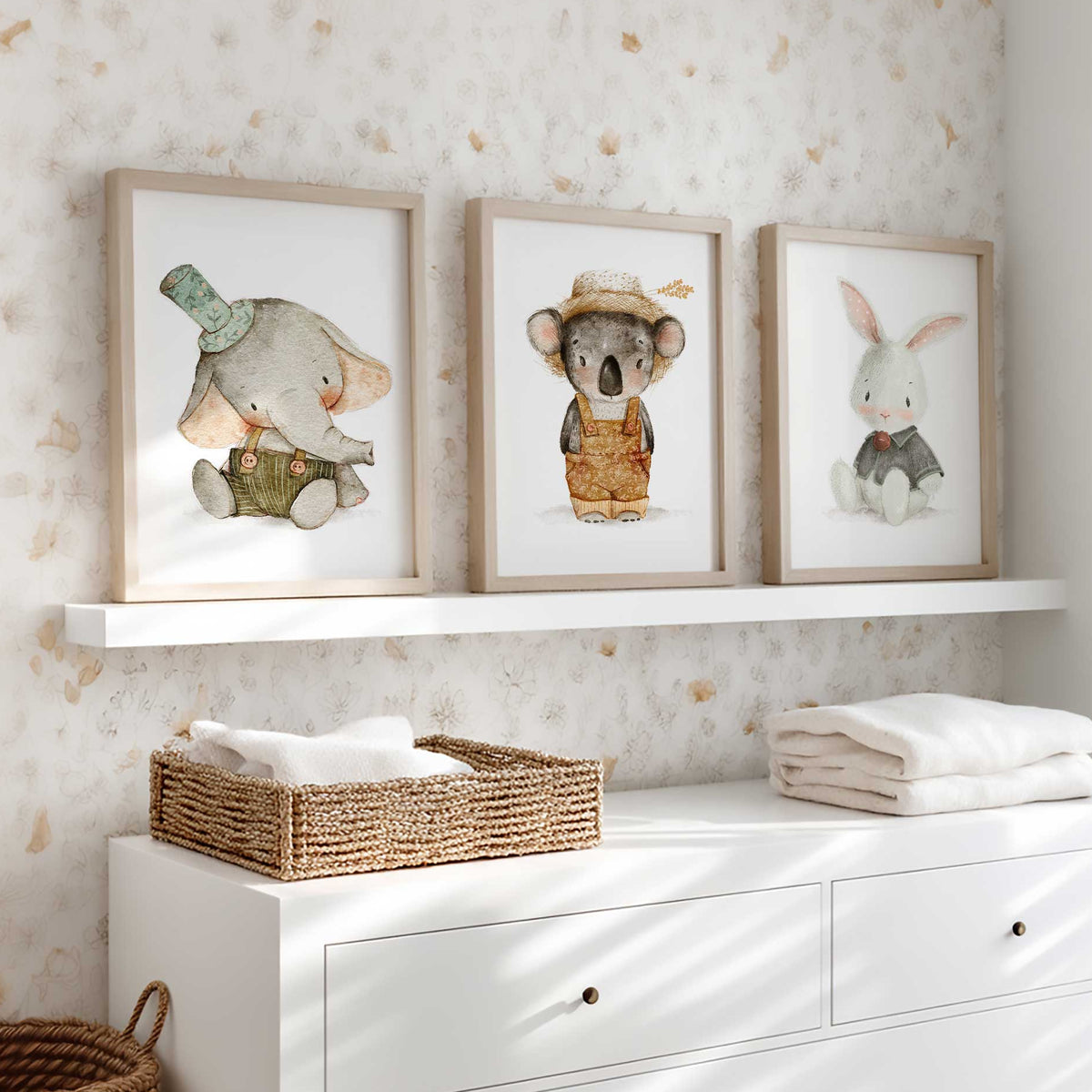 Three nursery prints showing an elephant in a green hat, a koala in ochre dungarees and a bunny in green.