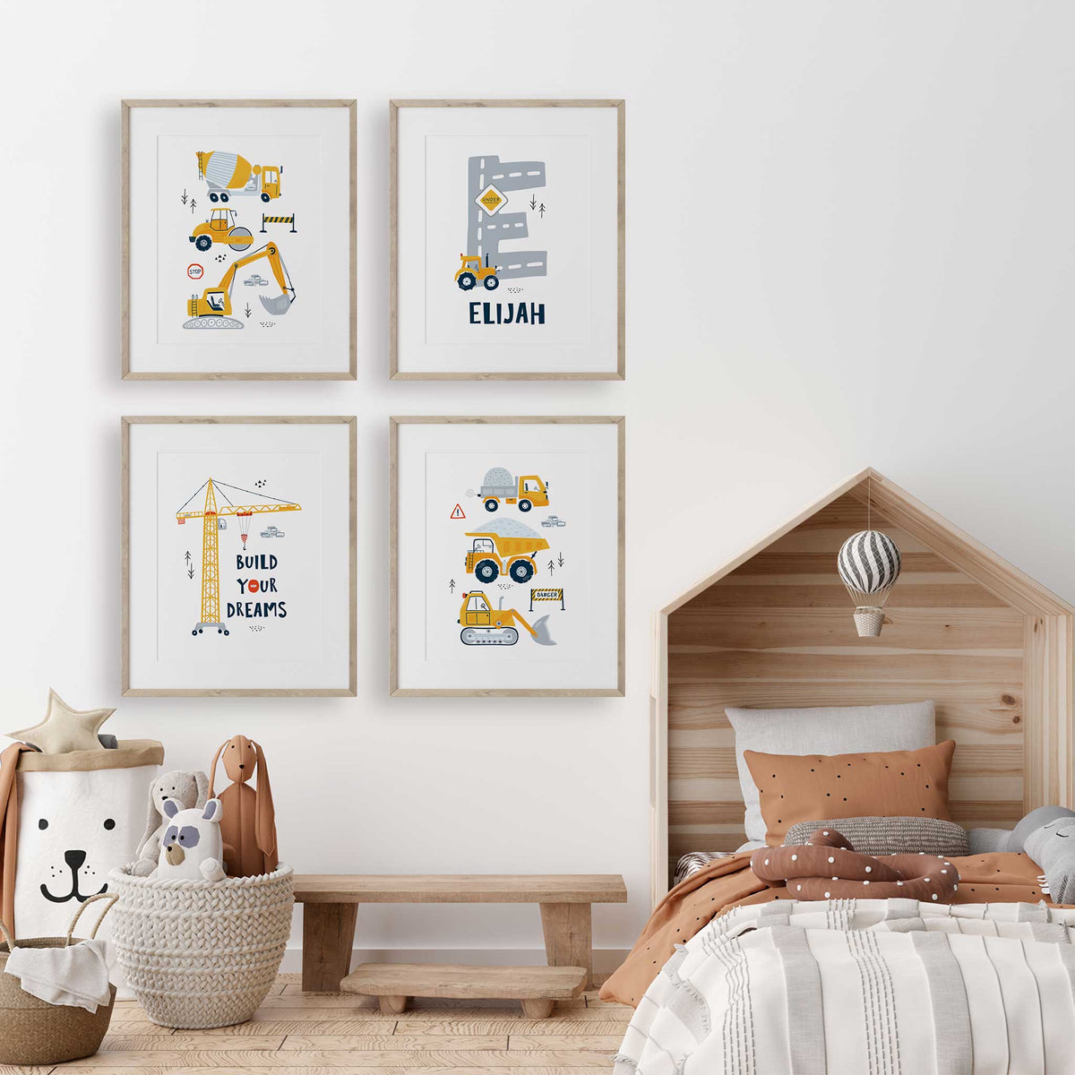 Construction wall art set of four with yellow vehicles, grey road initial and name, and Build Your Dreams crane art.