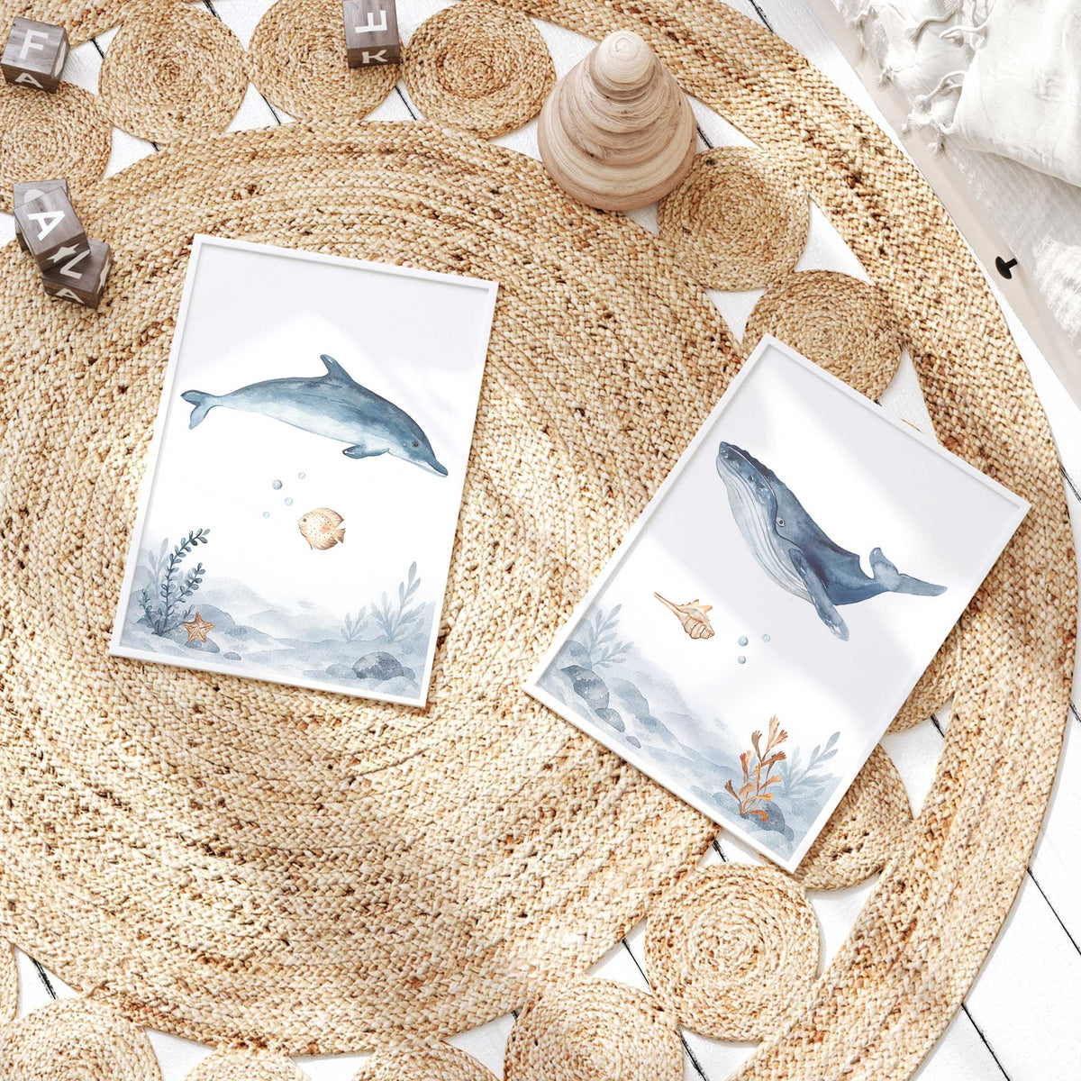 Blue watercolour dolphin and whale prints with a sandy fish, shells, starfish and coral above matching seabed scenes.