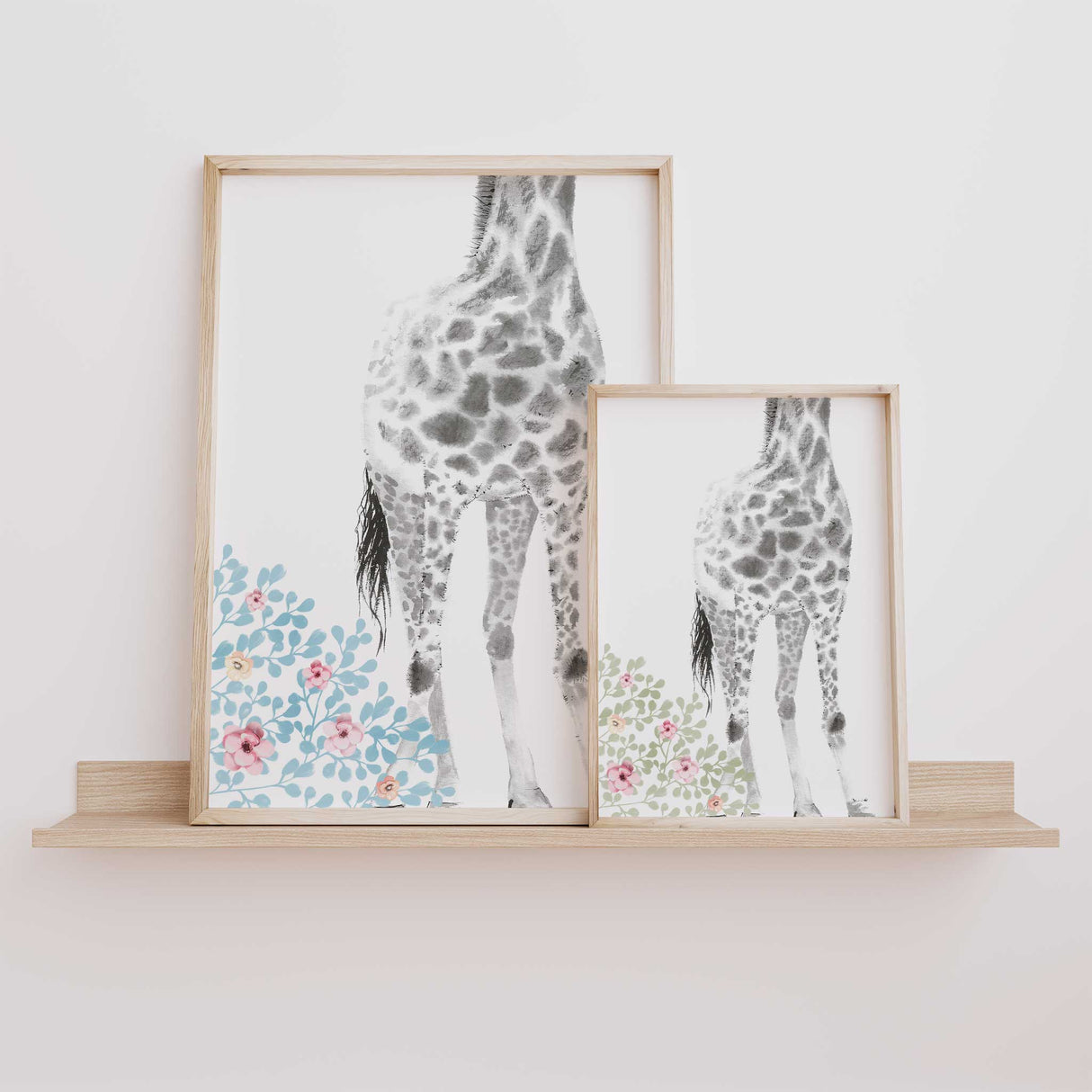 Girls nursery giraffe prints in pastel blue and sage floral styles displayed side by side to show both colour options for baby girl wall art.