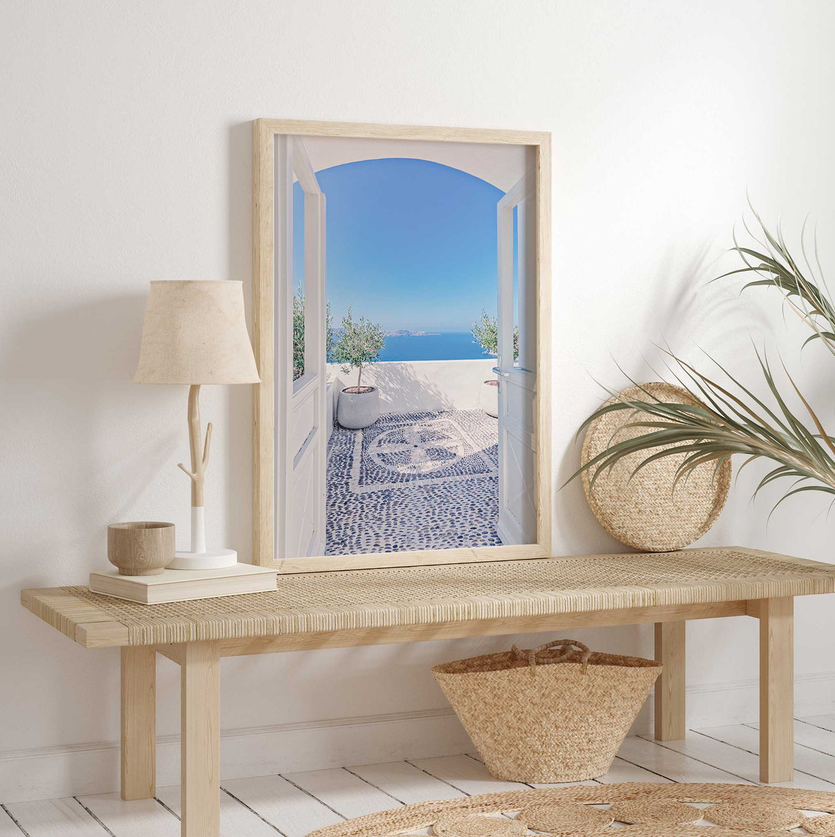 Sunlit seaside balcony with a pebble mosaic floor, potted olive trees, and a stunning blue horizon in the background.