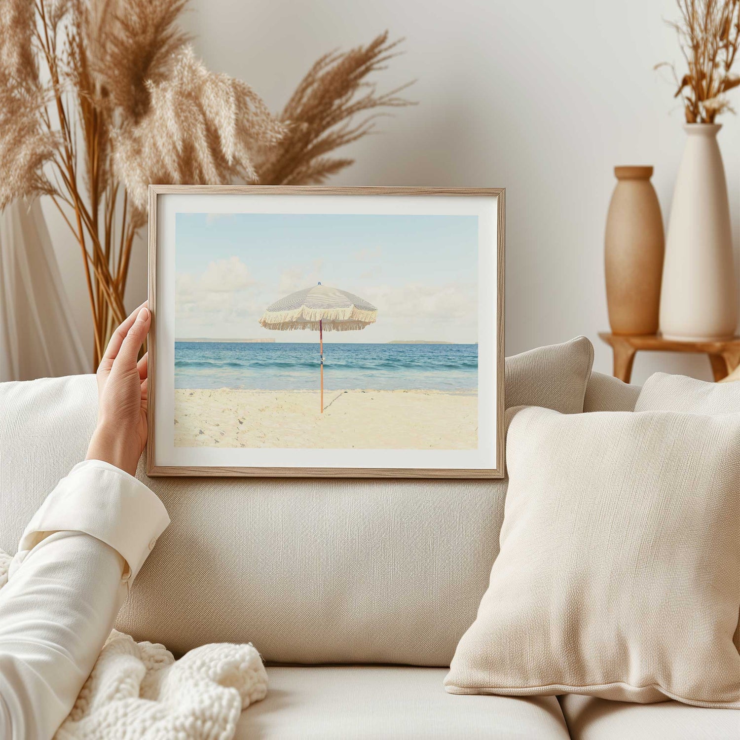 Neutral beach wall decor perfect for coastal homes, featuring a fringed parasol on the sand.