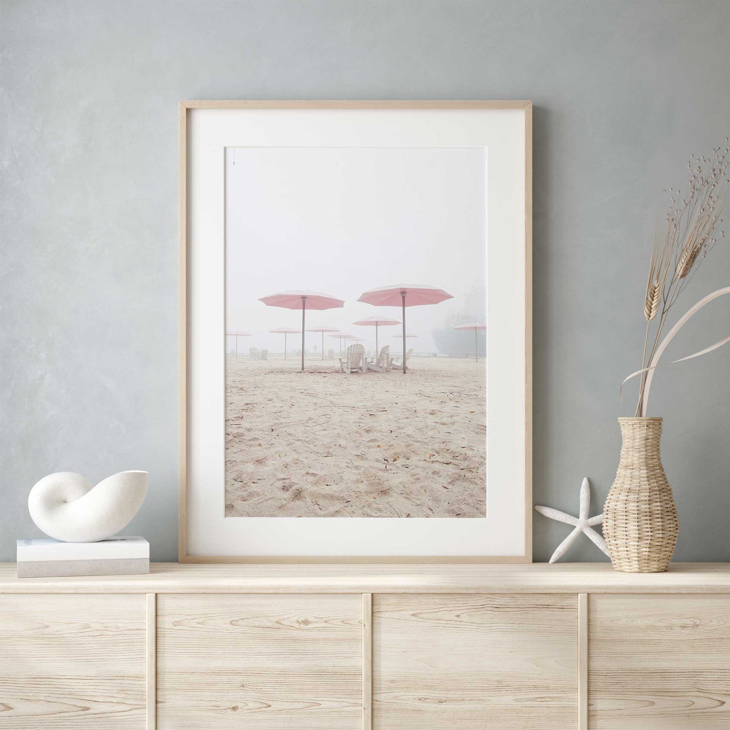 Neutral-toned beach photograph with soft sand and Adirondack chairs