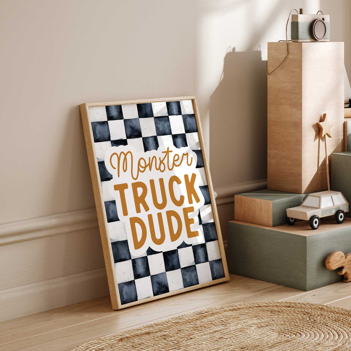Monster Truck Dude wall art with ochre script and bold block letters against a charcoal and off-white checkerboard.