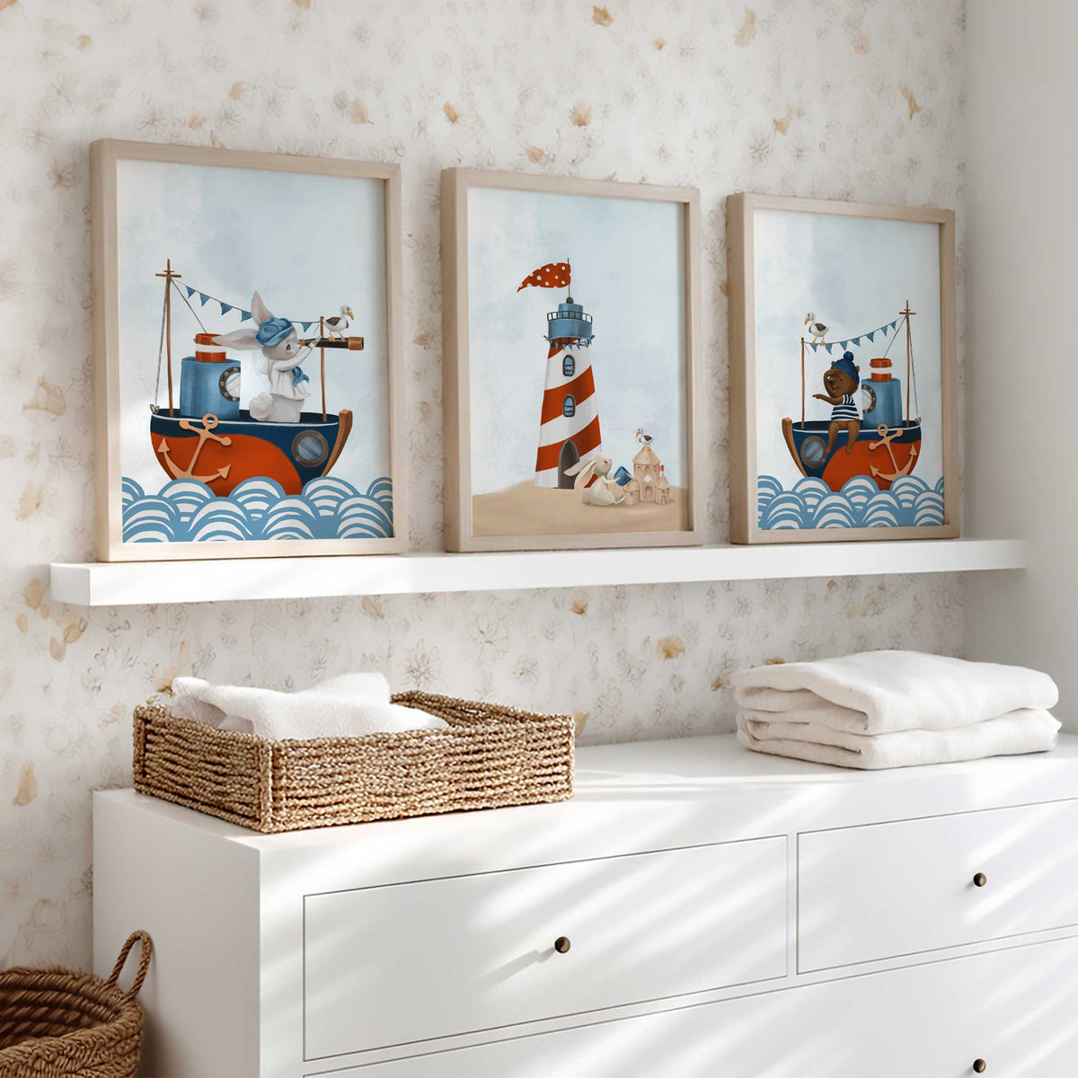 Set of three nautical nursery prints with a bunny sailor, teddy bear, red and white lighthouse and pale blue skies.
