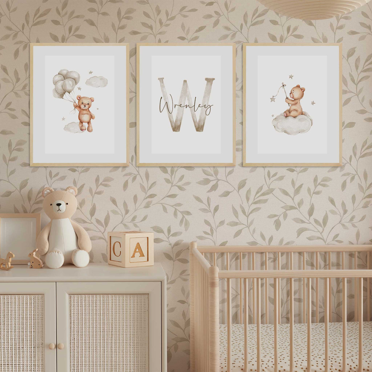 Set of three personalised teddy bear nursery prints with an initial and name displayed in a warm neutral nursery