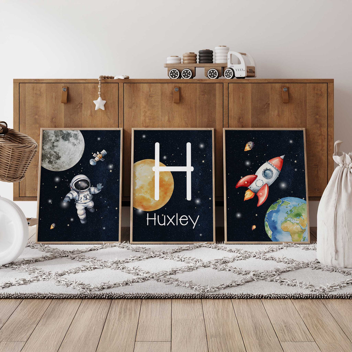 Space nursery wall art set with astronaut rocket and personalised initial print for boys room decor.