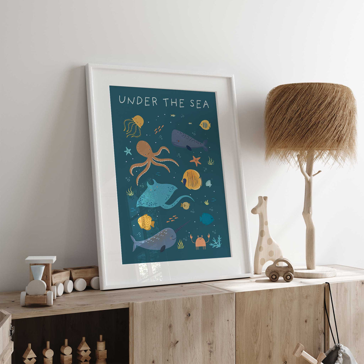 An illustrated kids poster with smiling sea animals like an octopus, stingray, narwhal, and fish, surrounded by bubbles, coral, and seaweed. The design is colorful and whimsical, perfect for a nursery or children's room