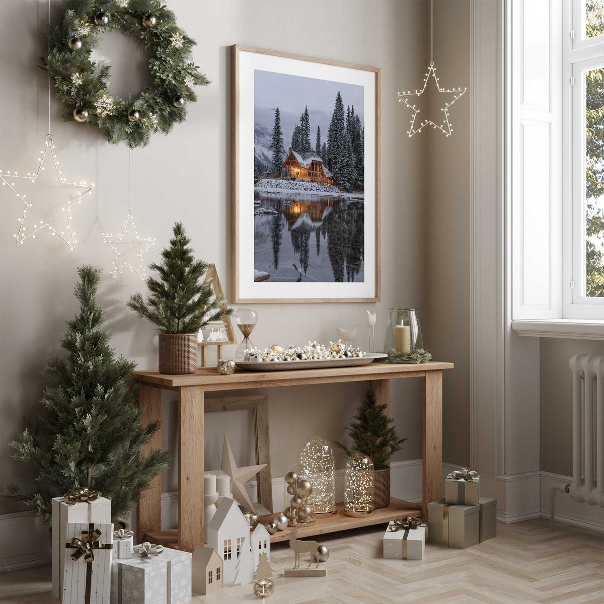 Winter cabin wall art showing warm lights reflected in a snowy lake, with pine trees and an even white border.