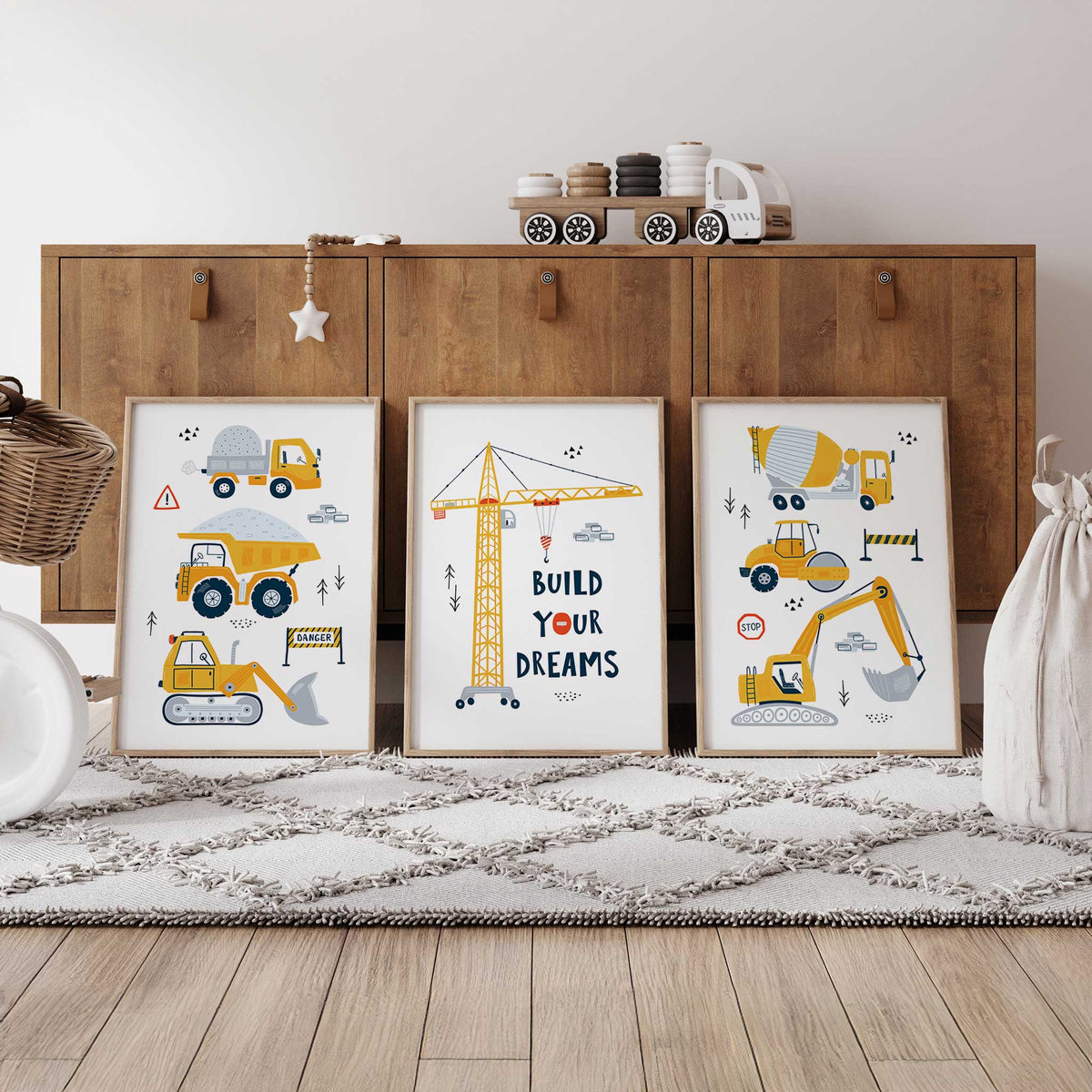 Three construction prints with stacked yellow trucks and diggers, grey details and a Build Your Dreams crane on white.