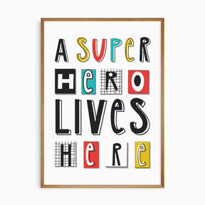 A Superhero Lives Here print with bold mixed typography for kids rooms