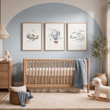 Set of three blue airplane nursery prints featuring an aeroplane, hot air balloon and helicopter for a boys bedroom.