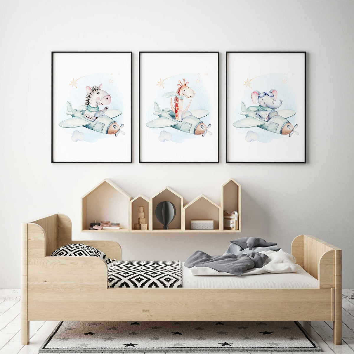 Set of three watercolour prints with zebra, giraffe and elephant pilots in mint aeroplanes, with clouds and stars on white.