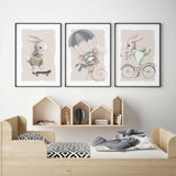 Three animal nursery prints with a skateboarding bunny, parachuting mouse and cycling bunny on soft beige backgrounds.