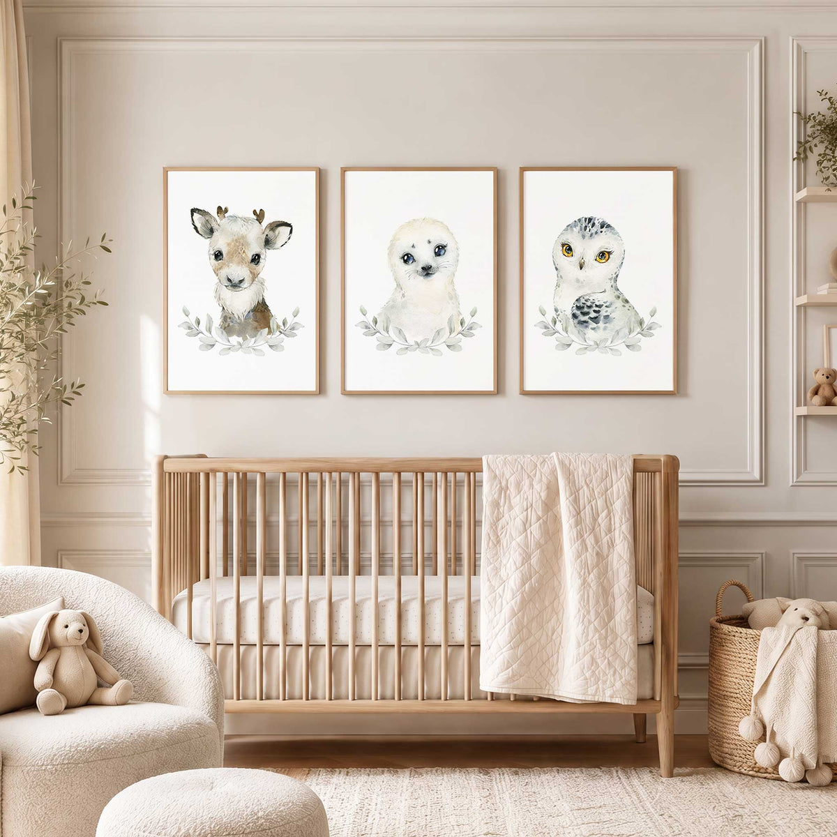 Arctic animal nursery wall art set of three featuring a baby reindeer, seal and snowy owl with pale leafy foliage.