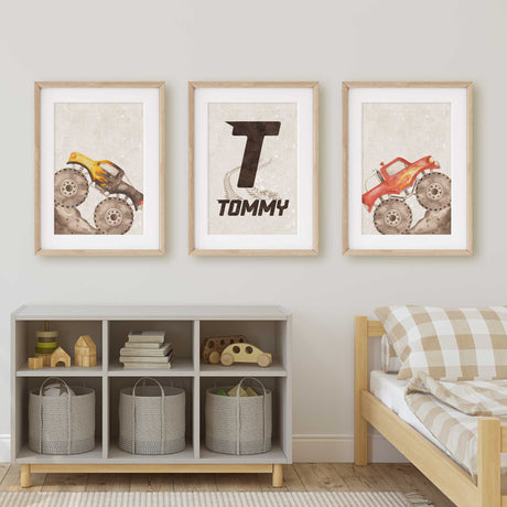 Yellow and red monster truck prints with muddy tyres and a personalised initial print on pale beige backgrounds.