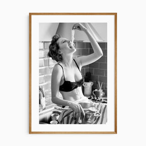 Black and white kitchen wall art featuring a woman eating spaghetti from the pot.