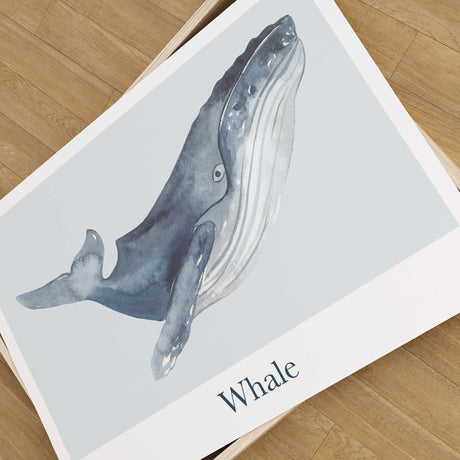 Close-up of a blue-grey watercolour whale print with detailed flippers, a pale blue-grey panel and the label Whale.