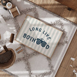Navy Long Live Boyhood lettering with a monster truck replacing the two O letters, against pale sage and cream stripes.