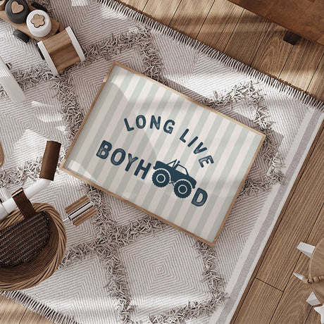 Navy Long Live Boyhood lettering with a monster truck replacing the two O letters, against pale sage and cream stripes.