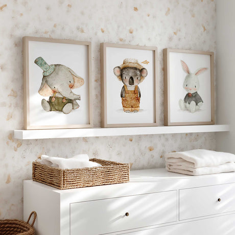 Three nursery prints showing an elephant in a green hat, a koala in ochre dungarees and a bunny in green.