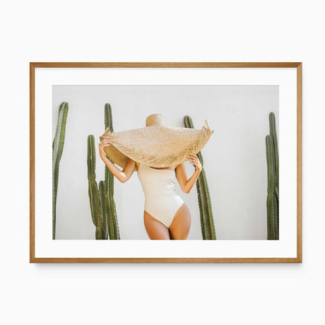 Cactus photography print showing a woman in an ivory swimsuit and oversized straw hat.