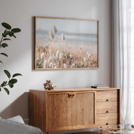 Coastal grass photography print showing soft beach reeds with a calm ocean visible in the background