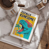 Colourful T-rex print with red shutter sunglasses, palm trees and bold black Totally Roarsome lettering.