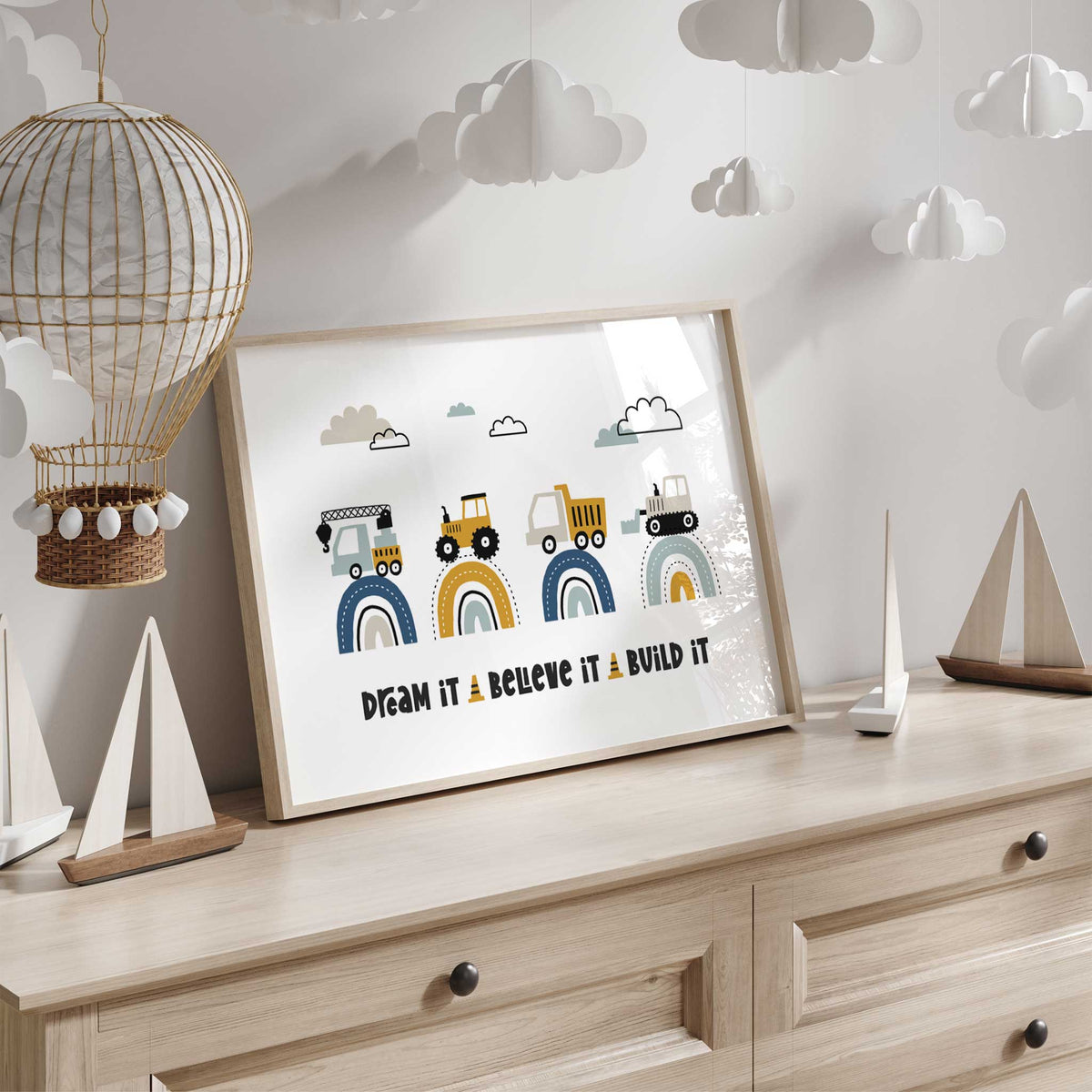 Crane truck, yellow tractor, dump truck and bulldozer on rainbow arches with the quote Dream It Believe It Build It.