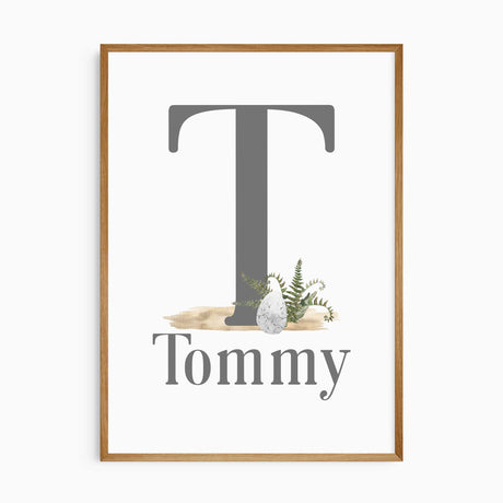 Personalised dinosaur initial print with a large grey initial, and childs' name, a dinosaur egg and green fern details.
