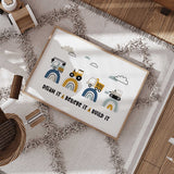 Dream It Believe It Build It print with four building vehicles on navy, mustard and aqua rainbows beneath clouds.