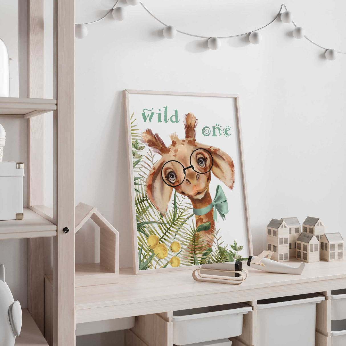 Adorable illustration of a playful giraffe wearing glasses and a bowtie, paired with the text "Wild One" and tropical foliage for a fun nursery vibe.