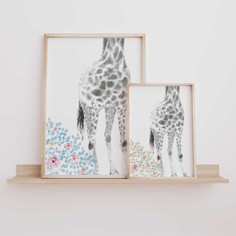 Girls nursery giraffe prints in pastel blue and sage floral styles displayed side by side to show both colour options for baby girl wall art.