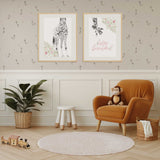 Nursery room prints showing the giraffe of 2 prints and hello beautiful text style above a cot or in a pastel girls bedroom.