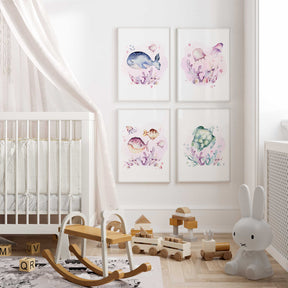 A set of four under the sea animal prints hanging on the wall of a nursery room, featuring a sea turtle, fish, jellyfish, and a whale.