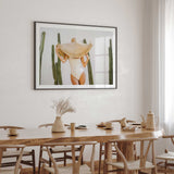 Landscape cactus wall print featuring a woman beneath an oversized straw hat.