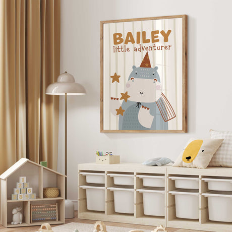Personalised hippo safari print wearing a party hat with child’s name and little adventurer wording for a nursery or kids room.