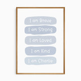 Blue affirmation print with white lettering reading I am Brave, I am Strong, I am Loved and I am Kind, plus a name.