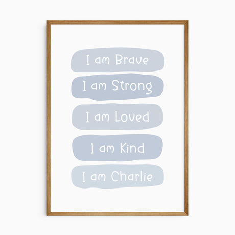 Blue affirmation print with white lettering reading I am Brave, I am Strong, I am Loved and I am Kind, plus a name.