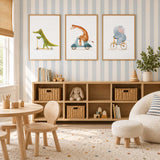 Set of three animal prints featuring a green crocodile, grey elephant and orange giraffe riding scooters and a bicycle.