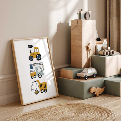 Construction wall art with a tractor, crane truck and dump truck in mustard, blue and grey on a white background.