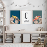 Personalised monster truck wall art with yellow and red trucks on blue and teal, plus a black initial and name.