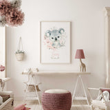 Personalised koala wall art with name in pink script, soft pink flowers and green foliage around a grey koala.