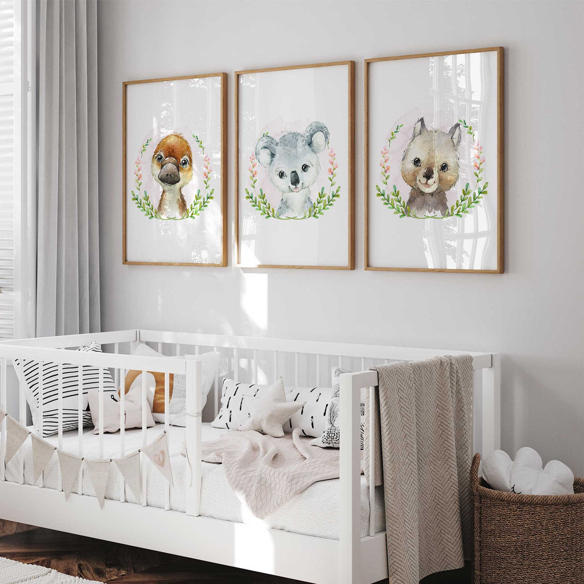 Three Australian animal portraits featuring a koala, platypus and wombat surrounded by green leaves and pink blossoms.