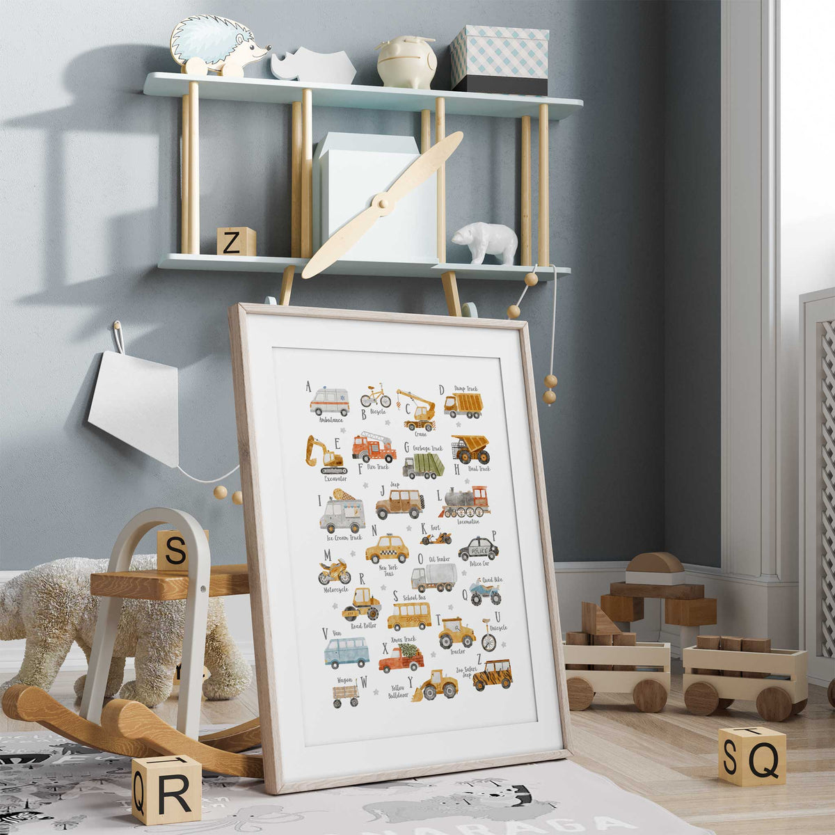 Watercolour transport alphabet with cars, trucks, bikes and a locomotive, each paired with a letter and vehicle name.
