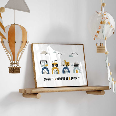 Landscape construction print with four vehicles, muted rainbow arches, clouds and Dream It Believe It Build It wording.
